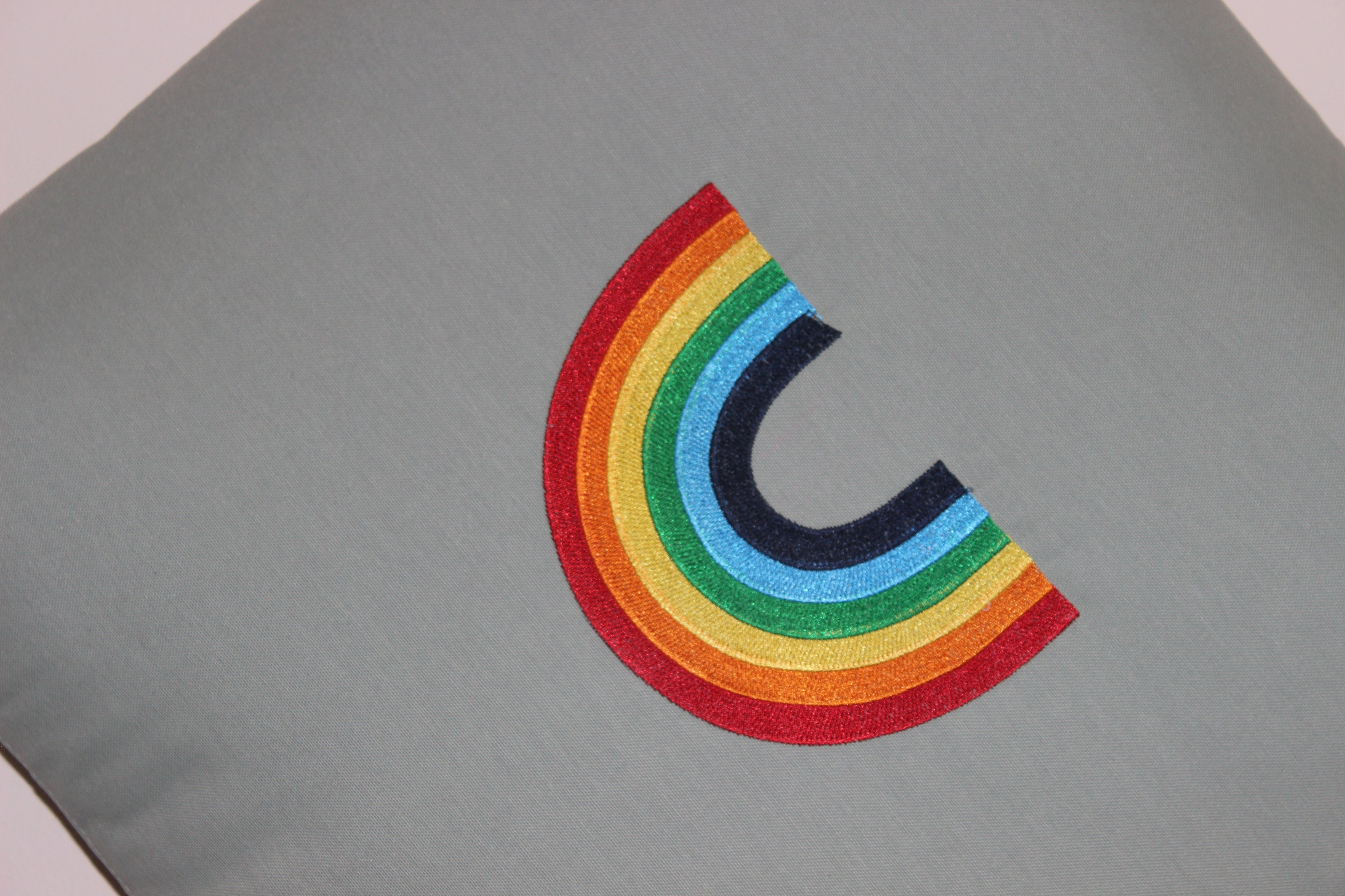 Close-up rainbow fabric on Mecks convertible cushion blanket zip