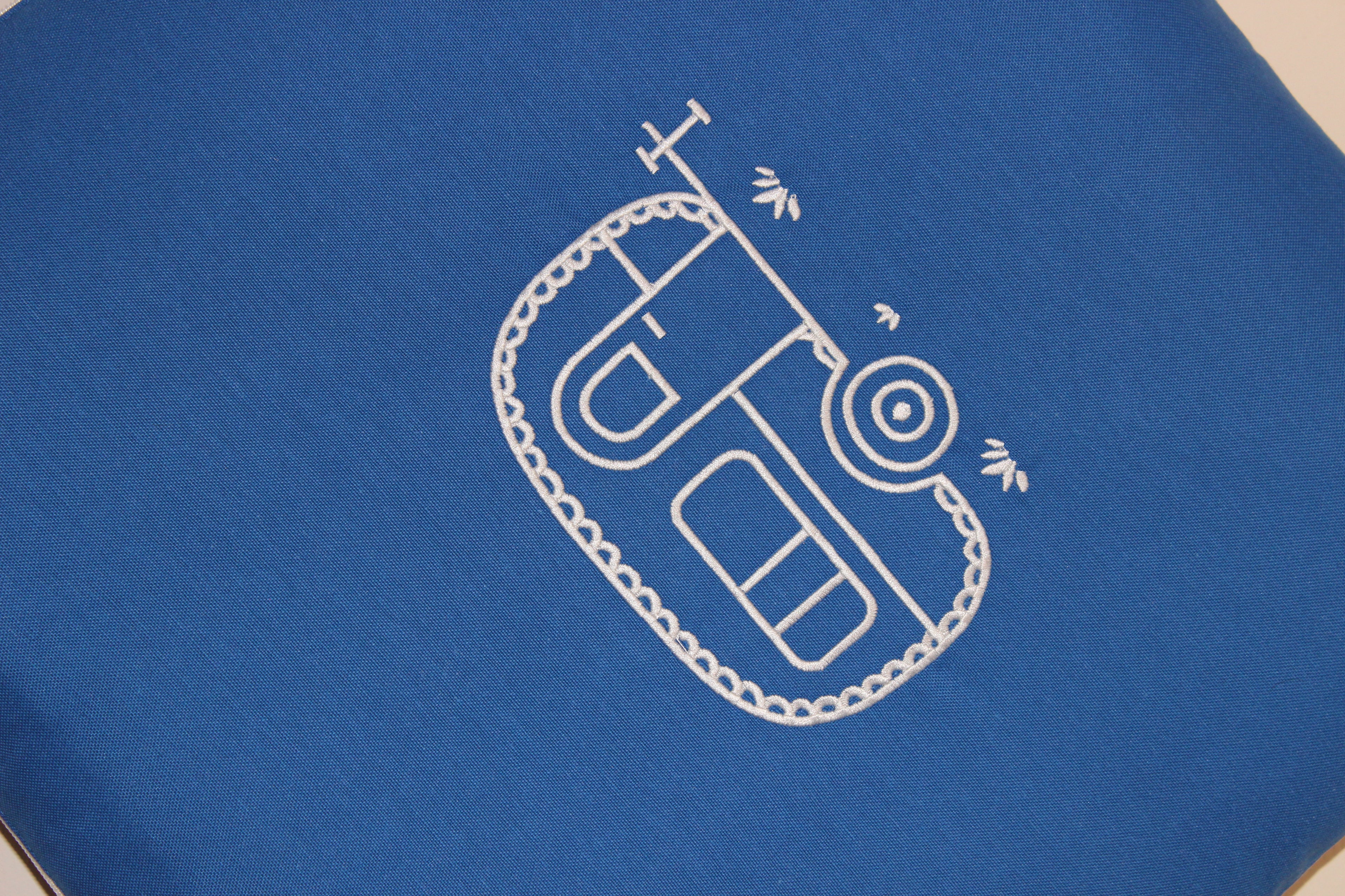 Close-up of Mecks RV cushion blanket embroidery and fabric detail