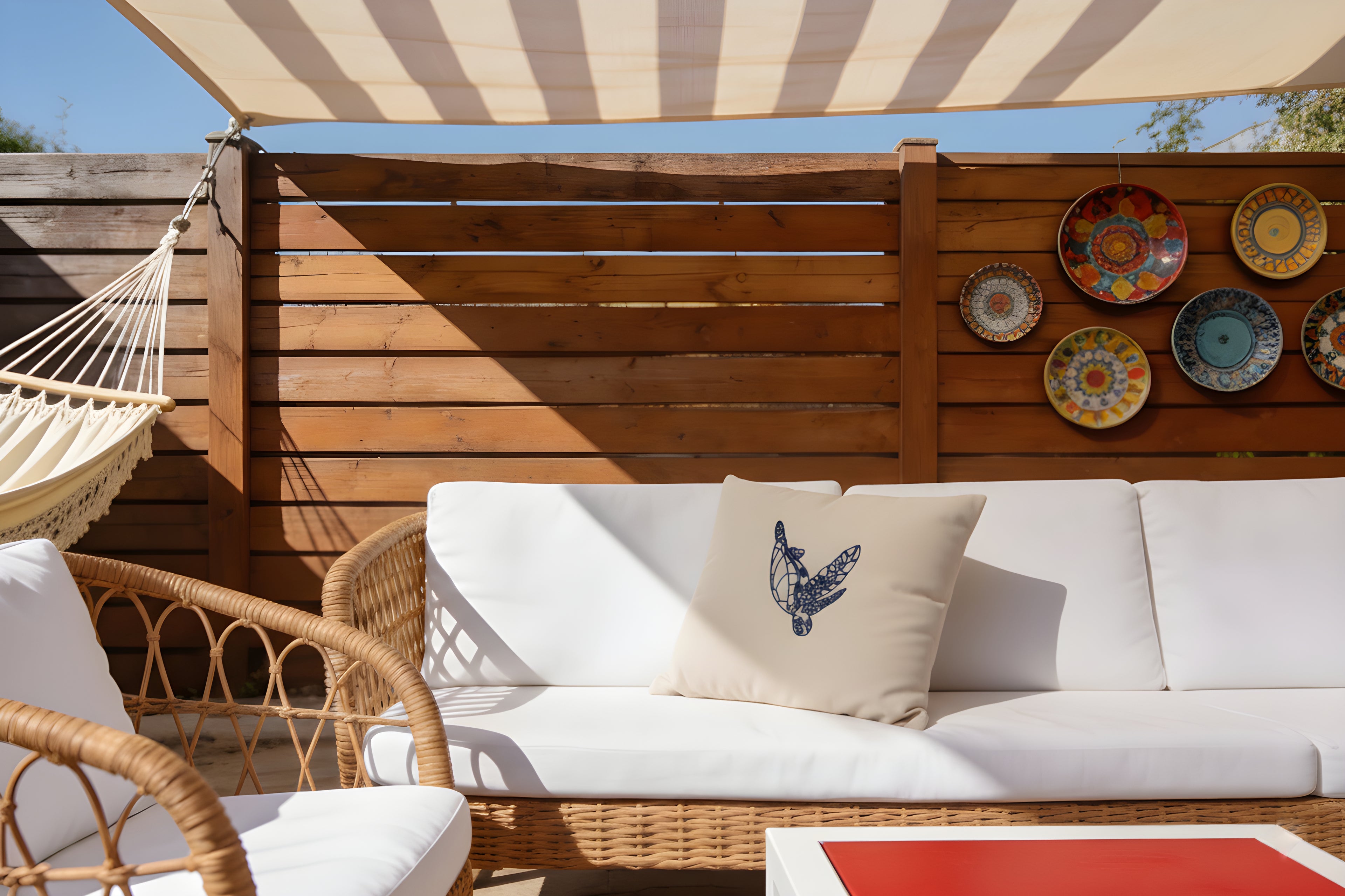 Outdoor seating area with a sofa, chairs, and a striped canopy on a wooden deck.